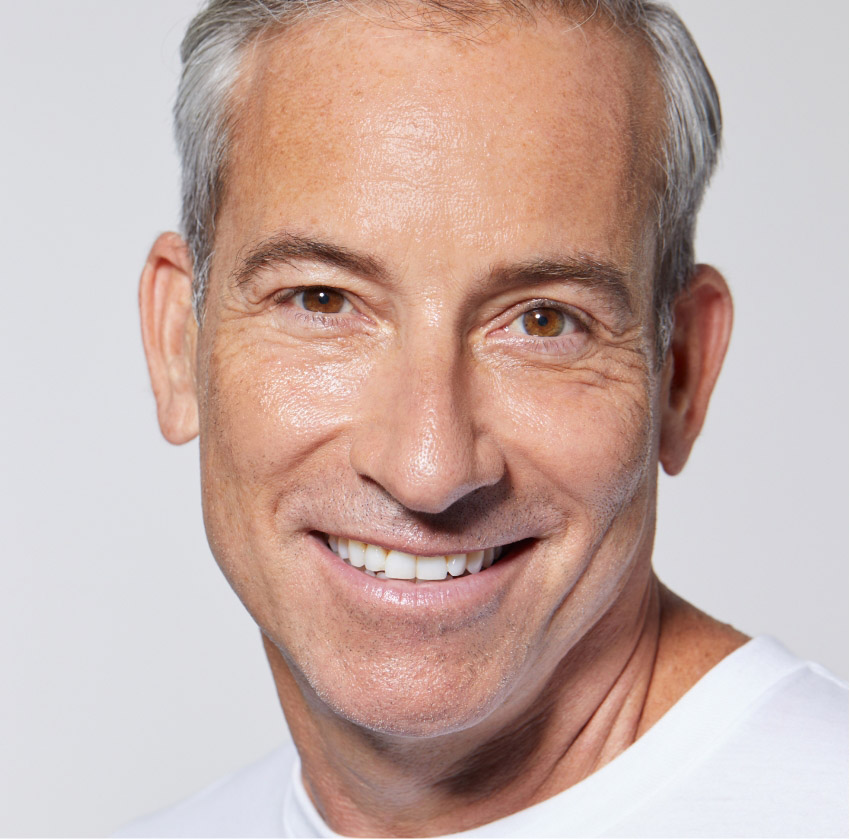 Smiling mature man with glowing skin after HydraFacial treatment