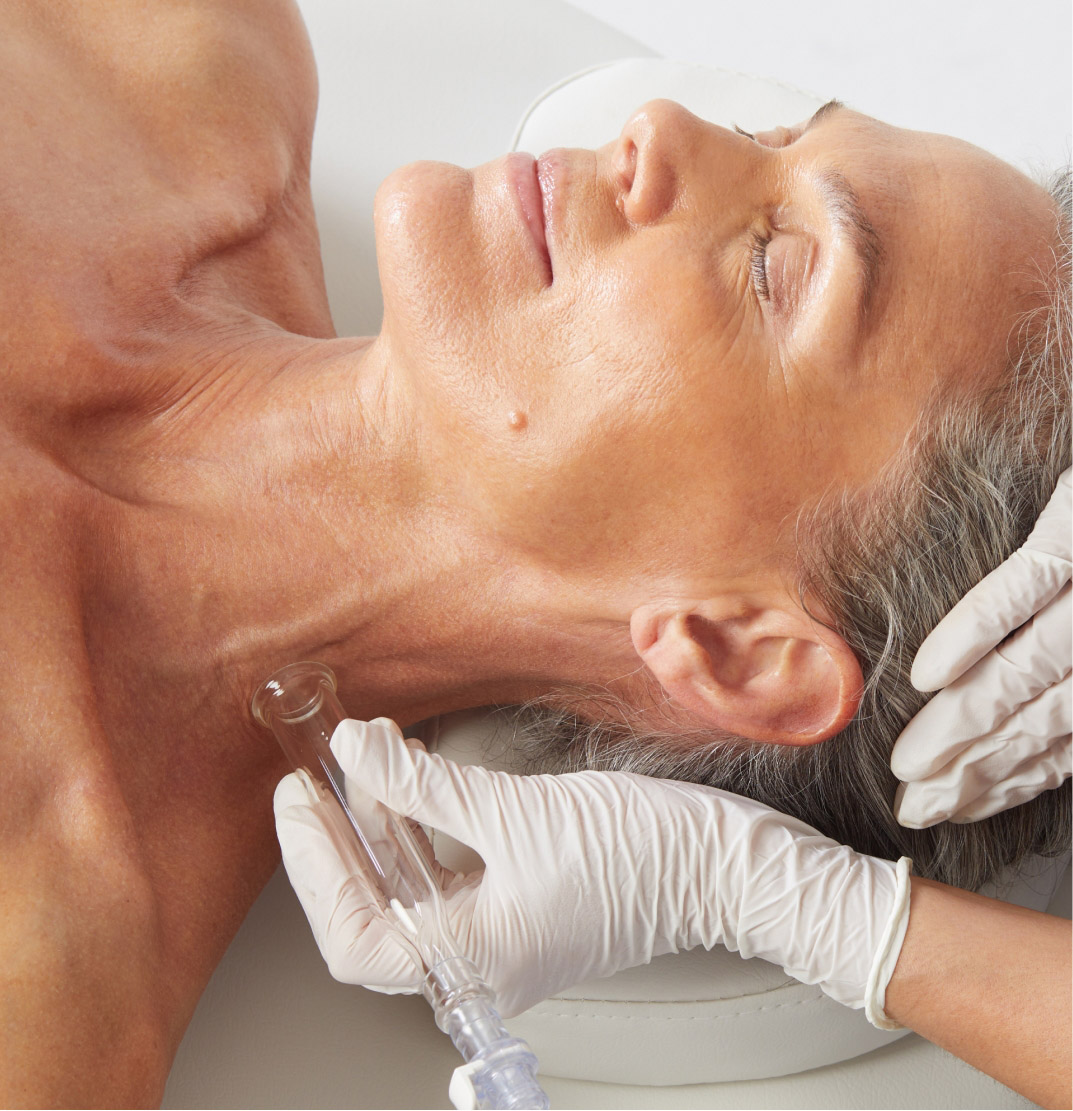 HydraFacial treatment being performed on a mature woman's neck for rejuvenated skin